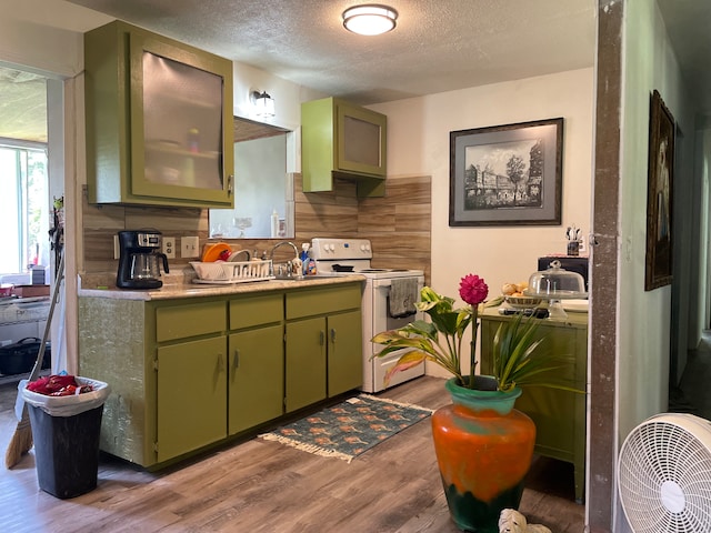 kitchen featuring light wood-type flooring, white electric stove, green cabinetry, and a textured ceiling