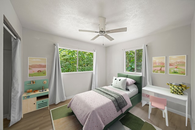 bedroom with a textured ceiling, ceiling fan, and dark hardwood / wood-style flooring