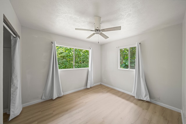 unfurnished bedroom featuring ceiling fan, a textured ceiling, and light hardwood / wood-style floors