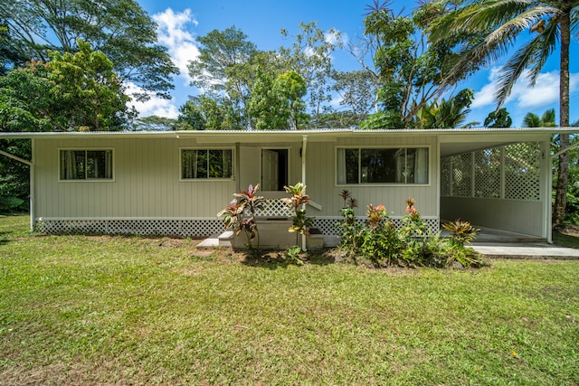 view of front of home with a front yard and a carport