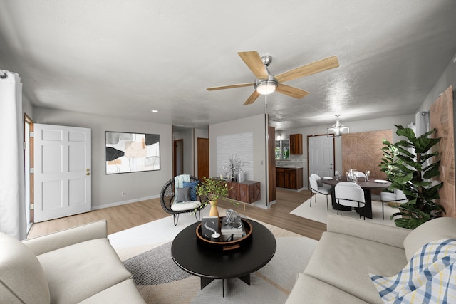 living room with light wood-type flooring, ceiling fan, and a wealth of natural light