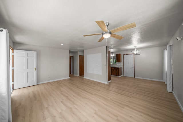 unfurnished living room with ceiling fan, a textured ceiling, and light wood-type flooring