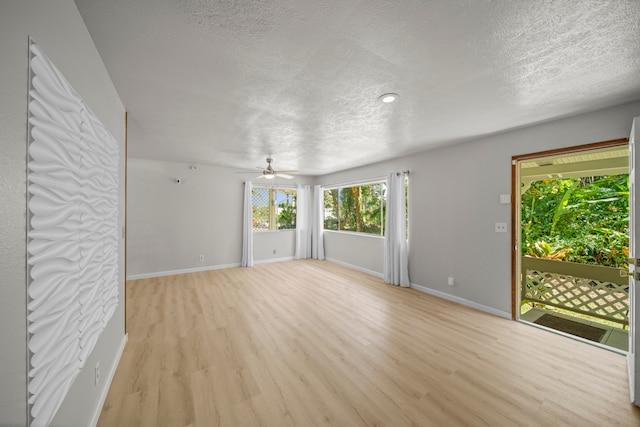 empty room with light wood-type flooring, ceiling fan, and a textured ceiling