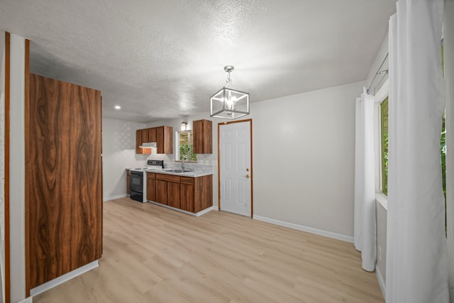 kitchen with a textured ceiling, sink, light hardwood / wood-style flooring, decorative light fixtures, and black range with electric cooktop