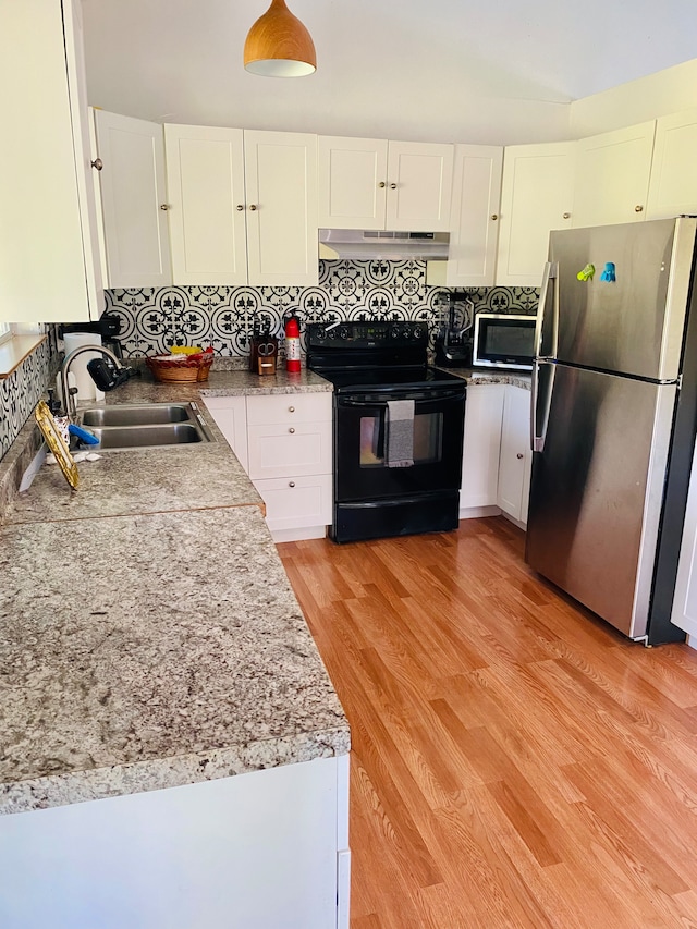 kitchen with appliances with stainless steel finishes, white cabinetry, sink, and light hardwood / wood-style flooring