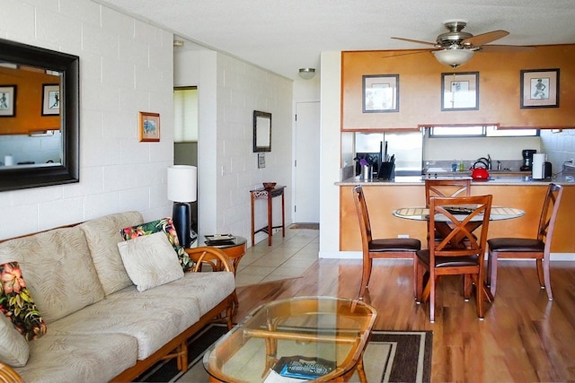 living room featuring a textured ceiling, ceiling fan, and hardwood / wood-style flooring