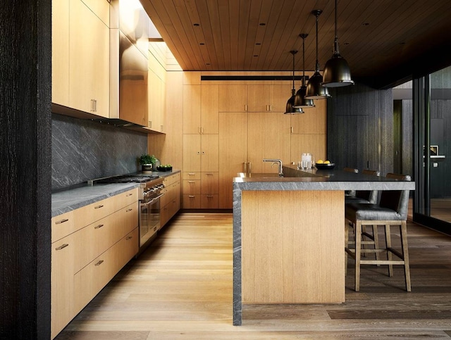 kitchen with high end stainless steel range, decorative light fixtures, wooden ceiling, a breakfast bar area, and light hardwood / wood-style floors