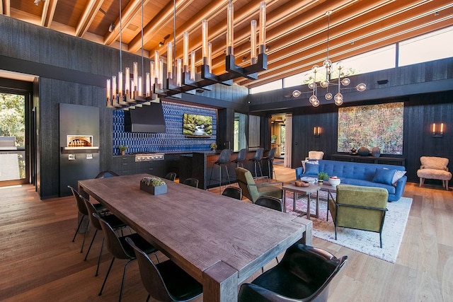 dining space with a towering ceiling, hardwood / wood-style flooring, and a notable chandelier