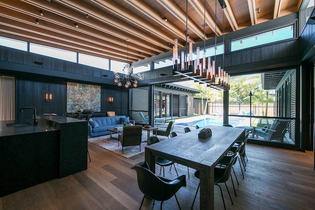 dining area with dark hardwood / wood-style flooring, a healthy amount of sunlight, sink, and a high ceiling