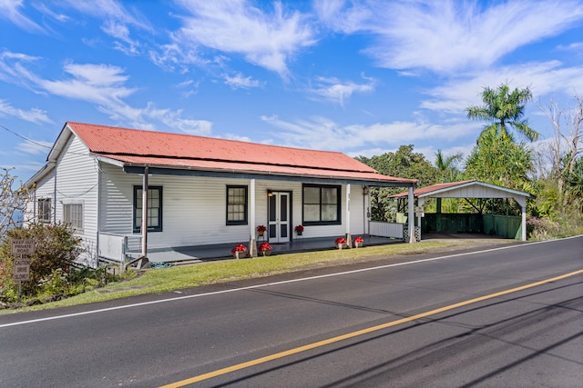 ranch-style home with covered porch and a carport