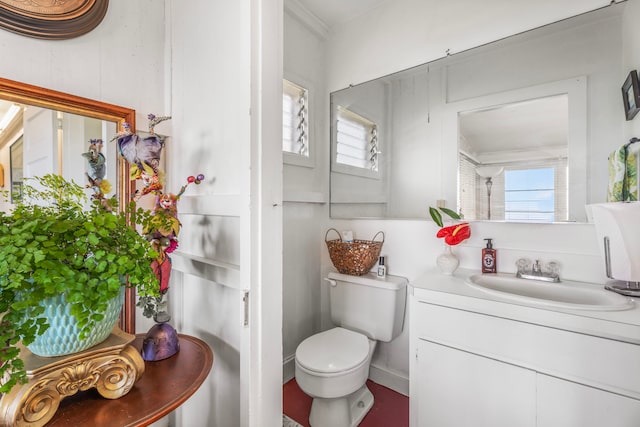 bathroom featuring plenty of natural light, toilet, crown molding, and vanity