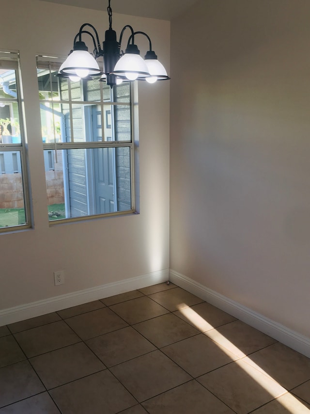 tiled empty room with a chandelier