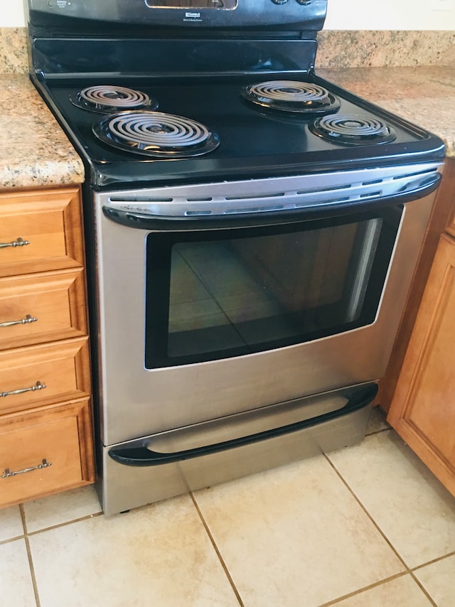 details with electric range and light tile patterned flooring