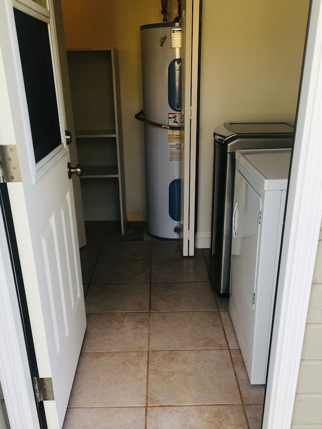 washroom with washer and dryer, light tile patterned floors, and electric water heater