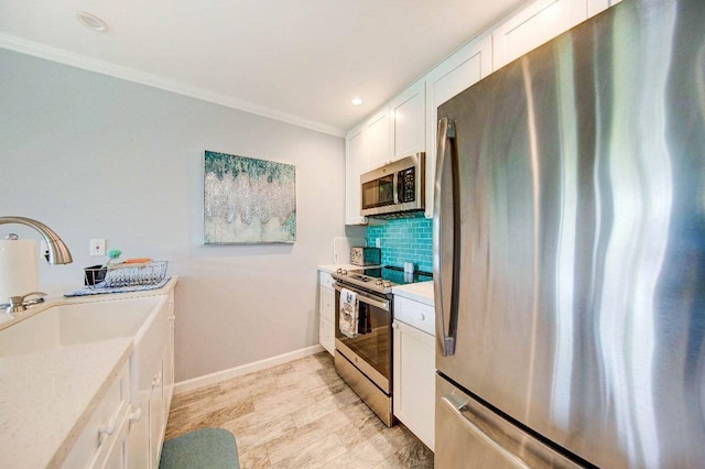 kitchen featuring light hardwood / wood-style flooring, stainless steel appliances, ornamental molding, decorative backsplash, and white cabinetry