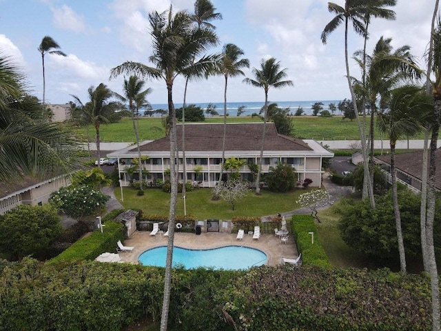 view of swimming pool with a water view, a lawn, and a patio area