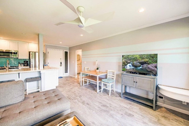 living room featuring ornamental molding and light hardwood / wood-style flooring