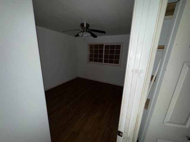 unfurnished room featuring ceiling fan and dark wood-type flooring