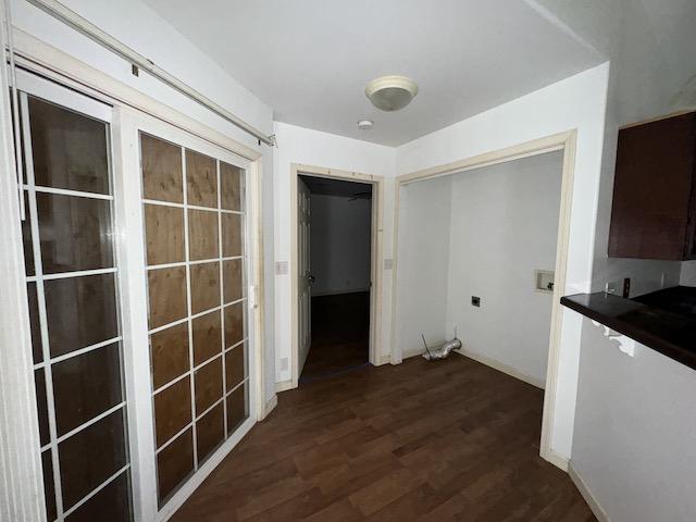 corridor with dark hardwood / wood-style flooring