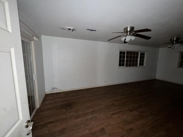 empty room featuring ceiling fan and dark wood-type flooring