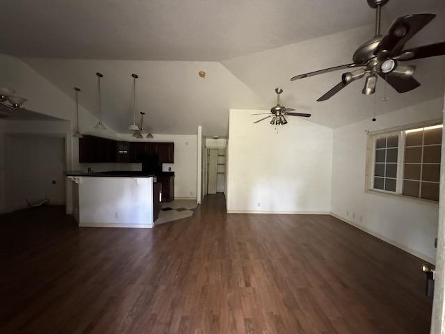 unfurnished living room with dark hardwood / wood-style flooring and vaulted ceiling