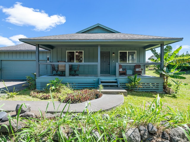 view of front of house with a garage, a front yard, and covered porch