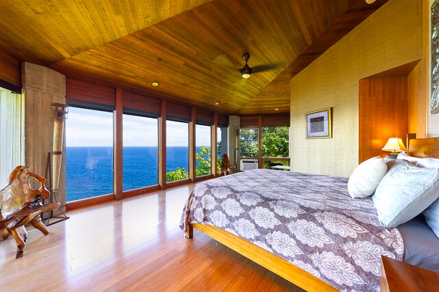 bedroom with access to outside, light hardwood / wood-style flooring, wooden ceiling, vaulted ceiling, and a water view