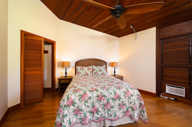 bedroom featuring an AC wall unit, wood ceiling, ceiling fan, and hardwood / wood-style floors