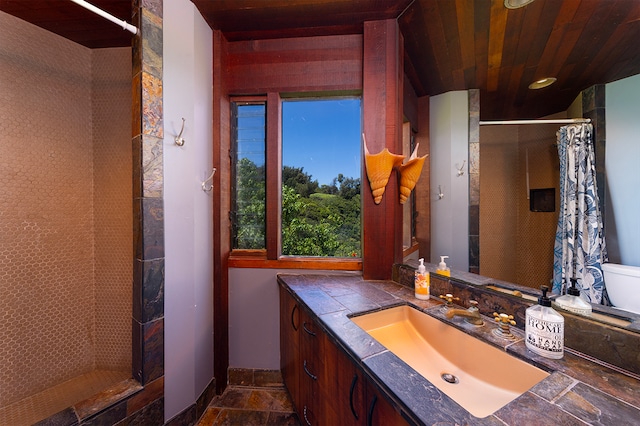 bathroom featuring wooden ceiling, walk in shower, and vanity