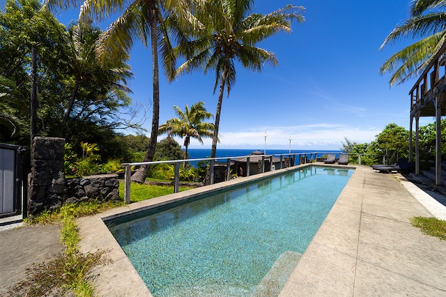 view of swimming pool with a patio and a water view