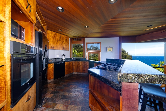 kitchen featuring a water view, a kitchen island, wooden ceiling, and black appliances