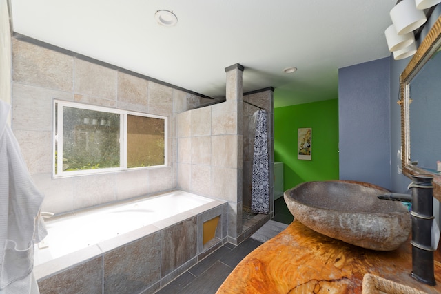 bathroom with tile walls, independent shower and bath, and tile patterned flooring