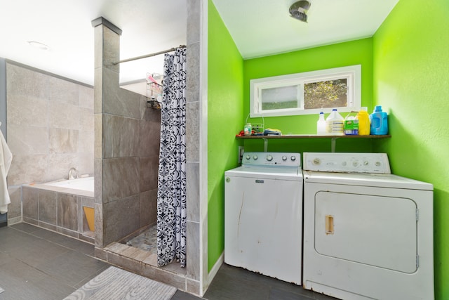 clothes washing area with independent washer and dryer and dark tile patterned flooring