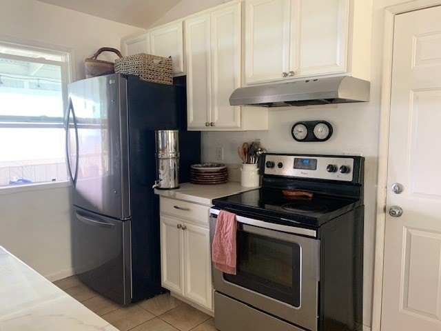 kitchen with appliances with stainless steel finishes, light tile patterned flooring, and white cabinets