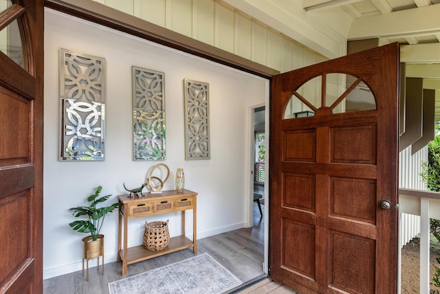 foyer entrance with beam ceiling, light hardwood / wood-style floors, and plenty of natural light