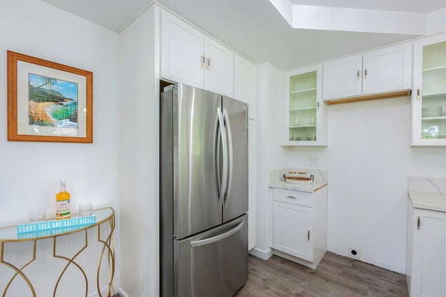 kitchen featuring white cabinets, dark hardwood / wood-style floors, and stainless steel refrigerator