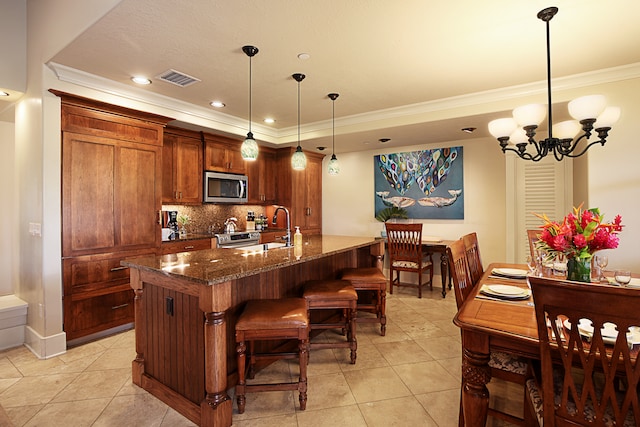 kitchen with dark stone countertops, tasteful backsplash, decorative light fixtures, ornamental molding, and a chandelier