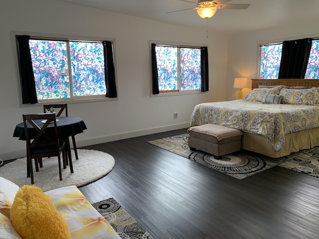 bedroom with multiple windows, ceiling fan, and hardwood / wood-style floors