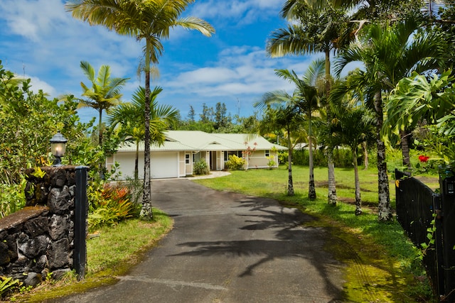 ranch-style home with a garage and a front lawn