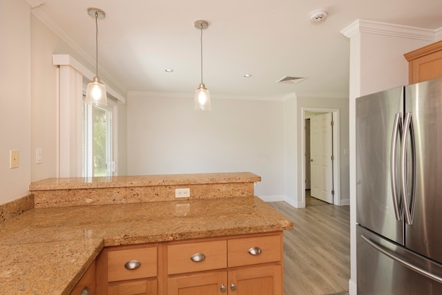 kitchen featuring stainless steel fridge, light stone counters, light hardwood / wood-style flooring, decorative light fixtures, and ornamental molding