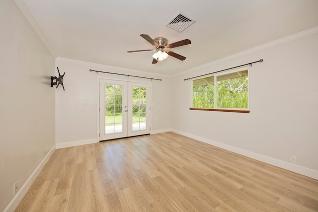 spare room featuring ornamental molding, a wealth of natural light, ceiling fan, and light wood-type flooring