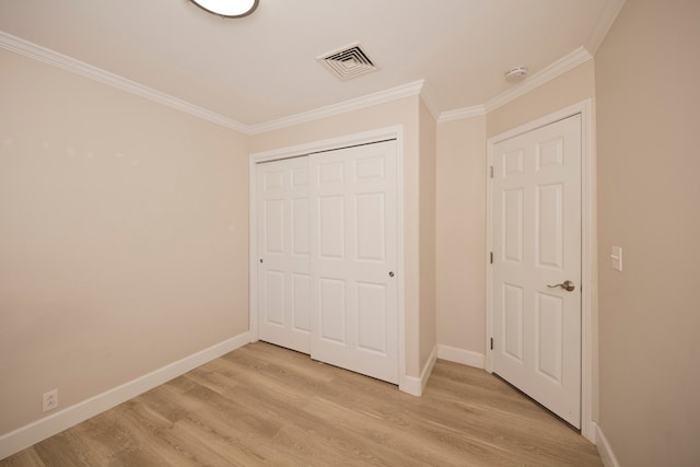 unfurnished bedroom featuring a closet, light hardwood / wood-style flooring, and ornamental molding