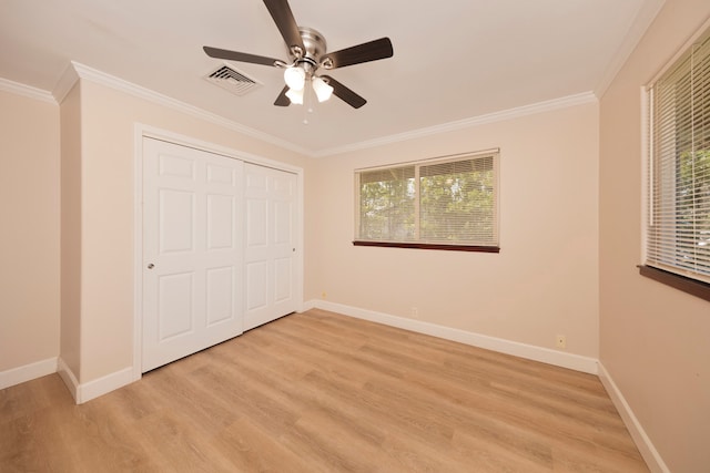 unfurnished bedroom with a closet, light wood-type flooring, ceiling fan, and crown molding