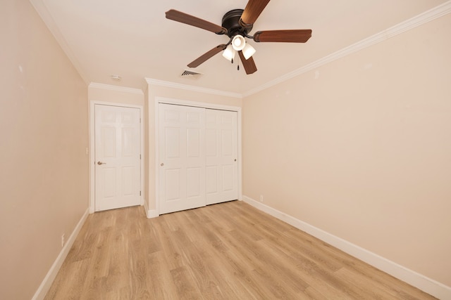 unfurnished bedroom with ceiling fan, light hardwood / wood-style flooring, crown molding, and a closet