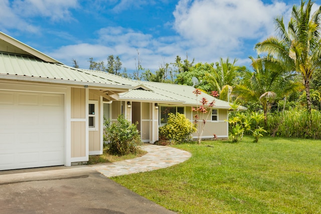 entrance to property featuring a lawn and a garage