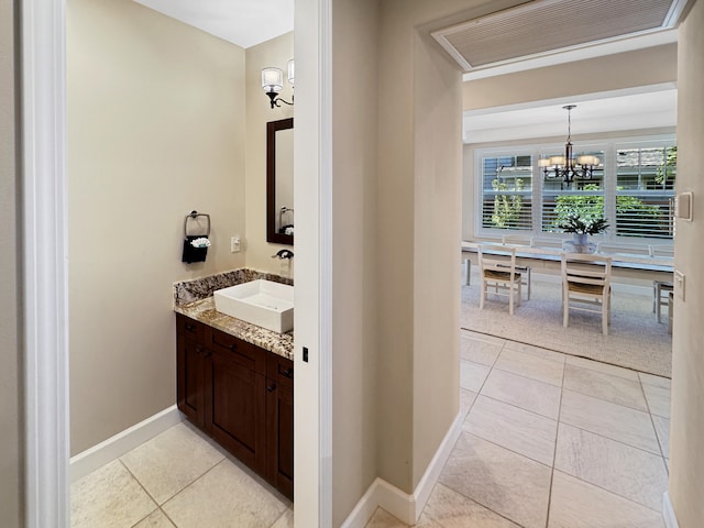 bathroom with tile patterned floors, vanity, and an inviting chandelier