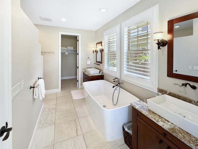 bathroom featuring a washtub, vanity, and tile patterned floors