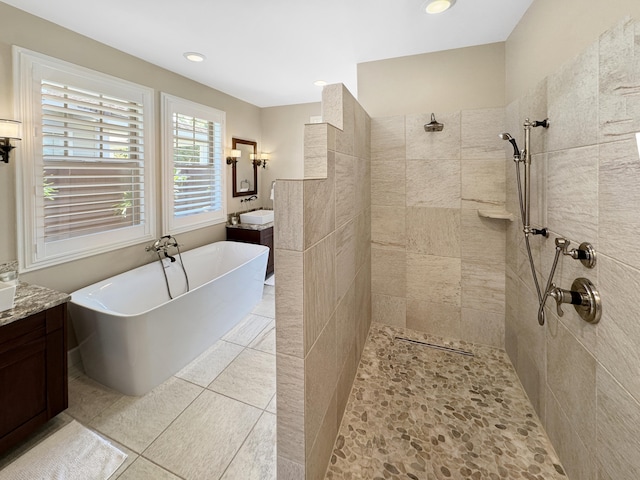 bathroom featuring tile patterned flooring, vanity, and plus walk in shower