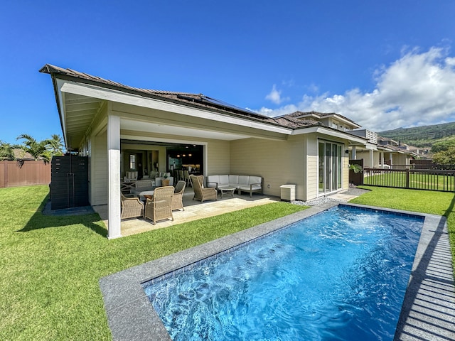 back of property with solar panels, a fenced in pool, an outdoor hangout area, and a yard