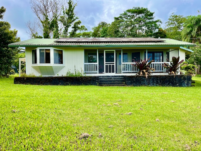 single story home featuring solar panels and a front lawn